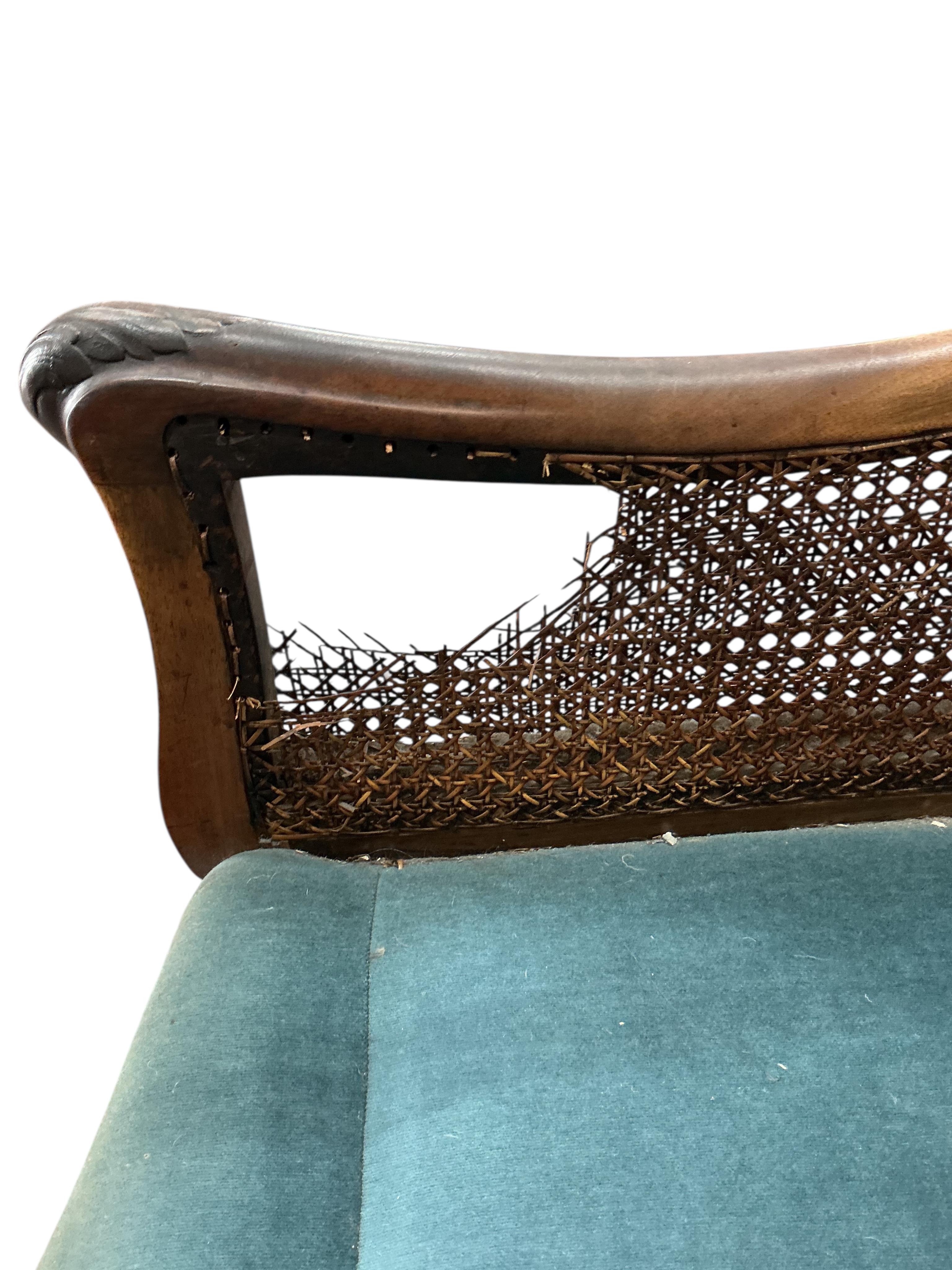 An early 20th century carved walnut and double canework three piece bergère suite, cane in need of repair